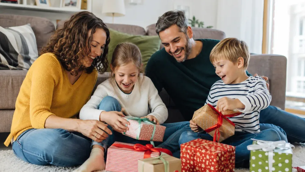 Familie packt gemeinsam personalisierte Geschenke aus